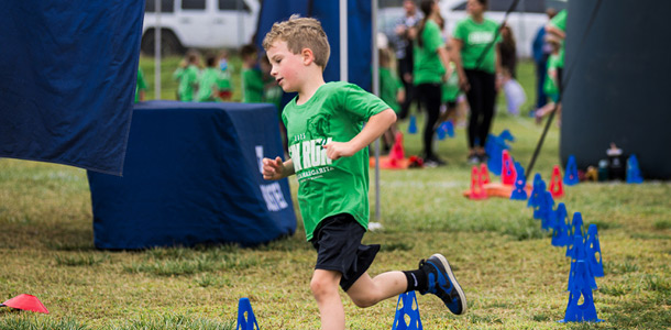 A student running at the Boosters Mustang Fun Run